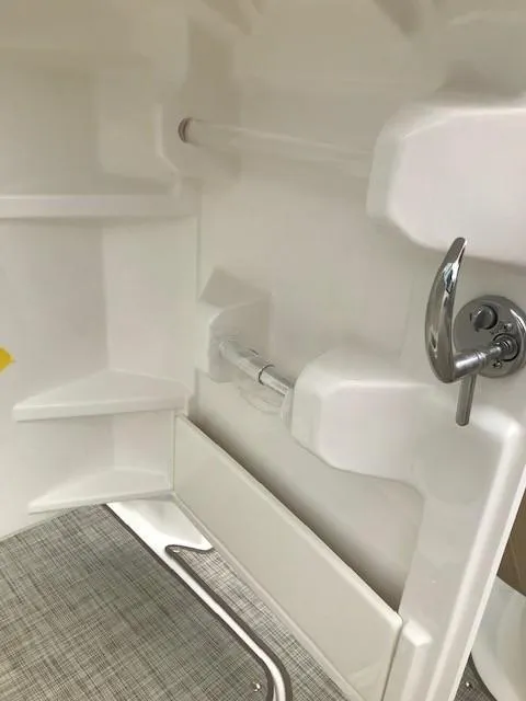 Slide: The Image of Interior view of 2019 NauticStar 2302 LDC boat, featuring sleek white design and chrome details. - 25