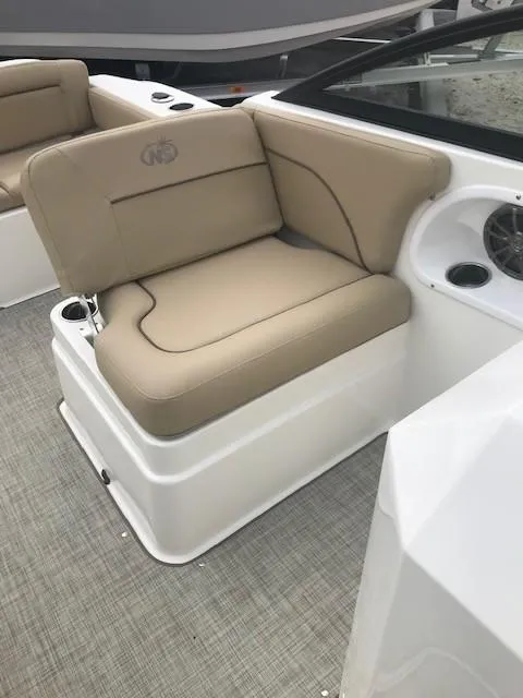 Slide: The Image of 2019 NauticStar 2302 LDC boat interior with beige seating and cup holders. - 8