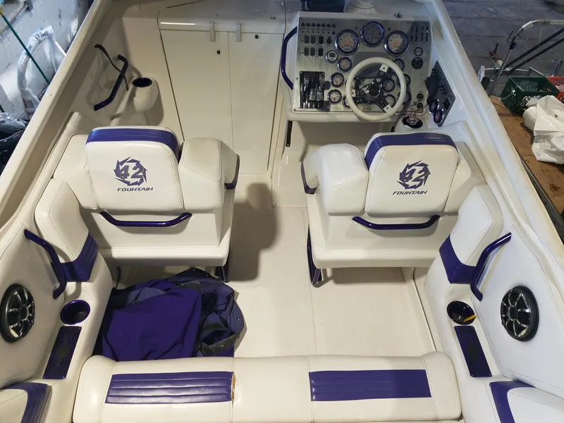 Slide: The Image of 2008 Fountain 42 Executioner boat interior with white and purple seating, dashboard, and controls. - 12