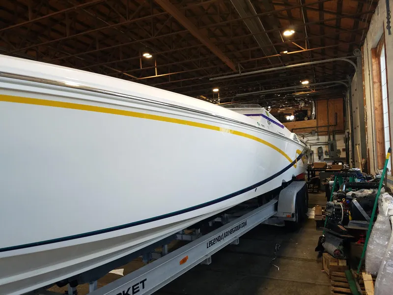 Slide: The Image of 2008 Fountain 42 Executioner boat in a warehouse, on a trailer, with yellow and blue stripes. - 20