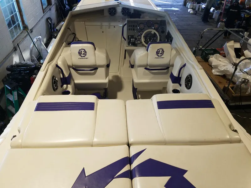 Slide: The Image of 2008 Fountain 42 Executioner boat interior with white and purple seating, dashboard, and controls. - 27