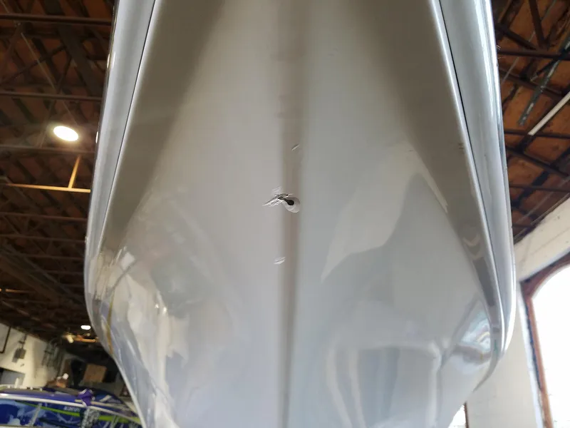 Slide: The Image of 2008 Fountain 42 Executioner boat hull with visible damage in a warehouse setting. - 34