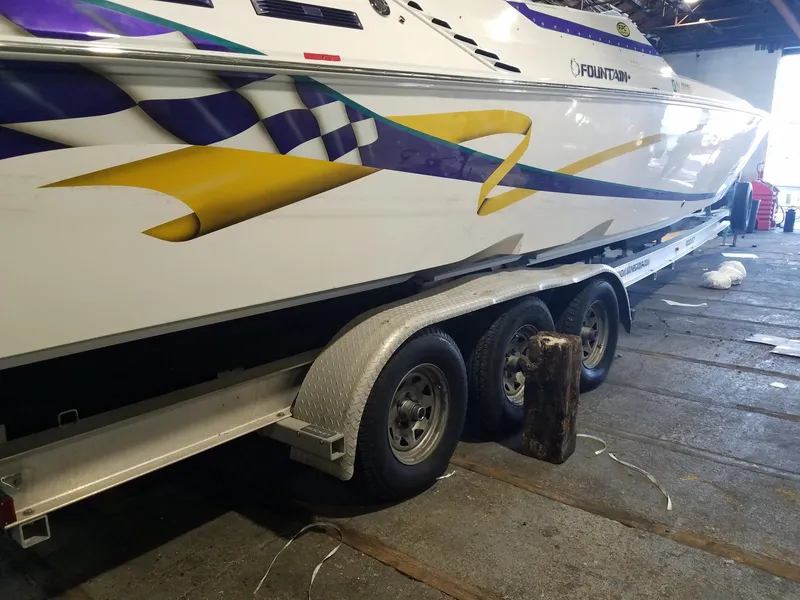 Slide: The Image of 2008 Fountain 42 Executioner boat on trailer with vibrant graphics in a garage setting. - 36