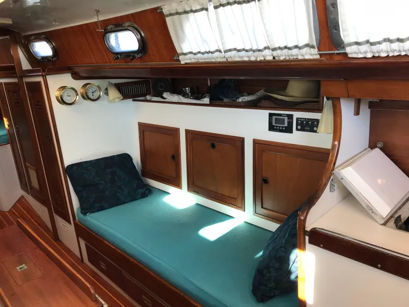 Slide: The Image of Interior of 1968 Hinckley Bermuda 40 sailboat with wooden cabinets and teal seating. - 10