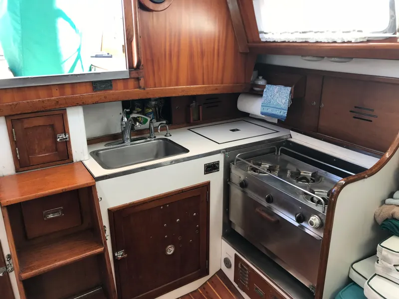 Slide: The Image of 1968 Hinckley Bermuda 40 yacht kitchen with wooden cabinetry, sink, and stove. - 11