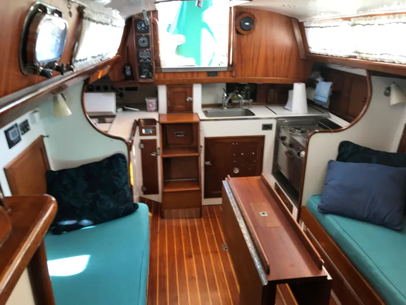 Slide: The Image of Interior of a 1968 Hinckley Bermuda 40 sailboat with wooden finishes and cozy seating. - 12