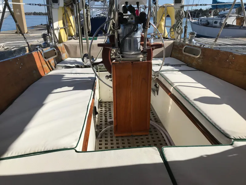 Slide: The Image of 1968 Hinckley Bermuda 40 sailboat cockpit with cushioned seating and wooden accents. - 13