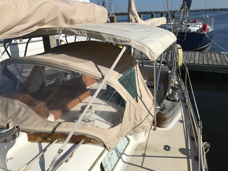 Slide: The Image of 1968 Hinckley Bermuda 40 sailboat docked, featuring beige canvas covers and wooden accents. - 6