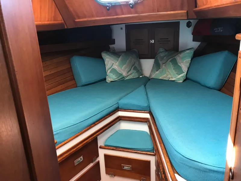 Slide: The Image of Interior cabin of a 1968 Hinckley Bermuda 40 sailboat with blue cushions and wooden finishes. - 7