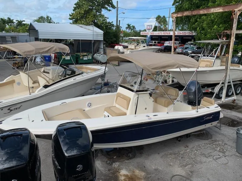 Slide: The Image of 2025 Scout 195 Sportfish boat with dual outboard motors in a marina. - 4