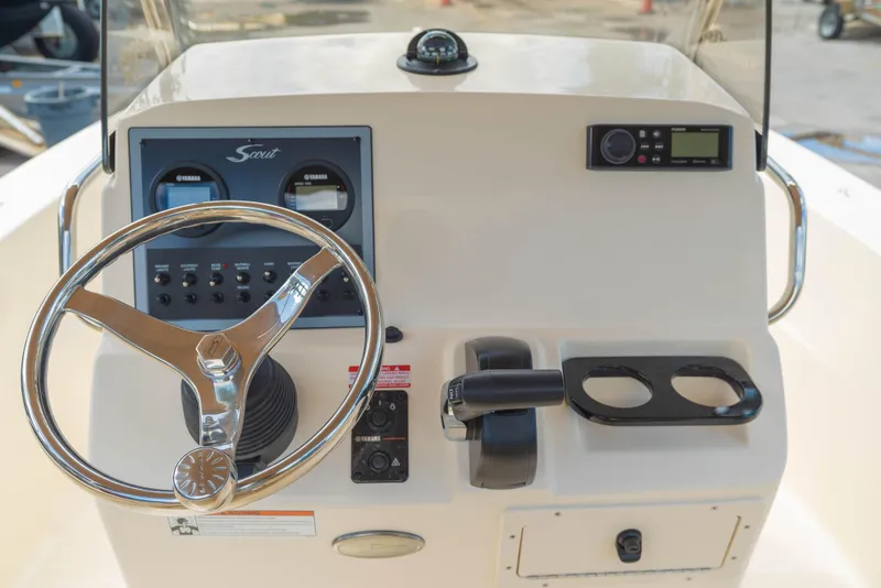 Slide: The Image of 2025 Scout 195 Sportfish boat dashboard with steering wheel and controls. - 5