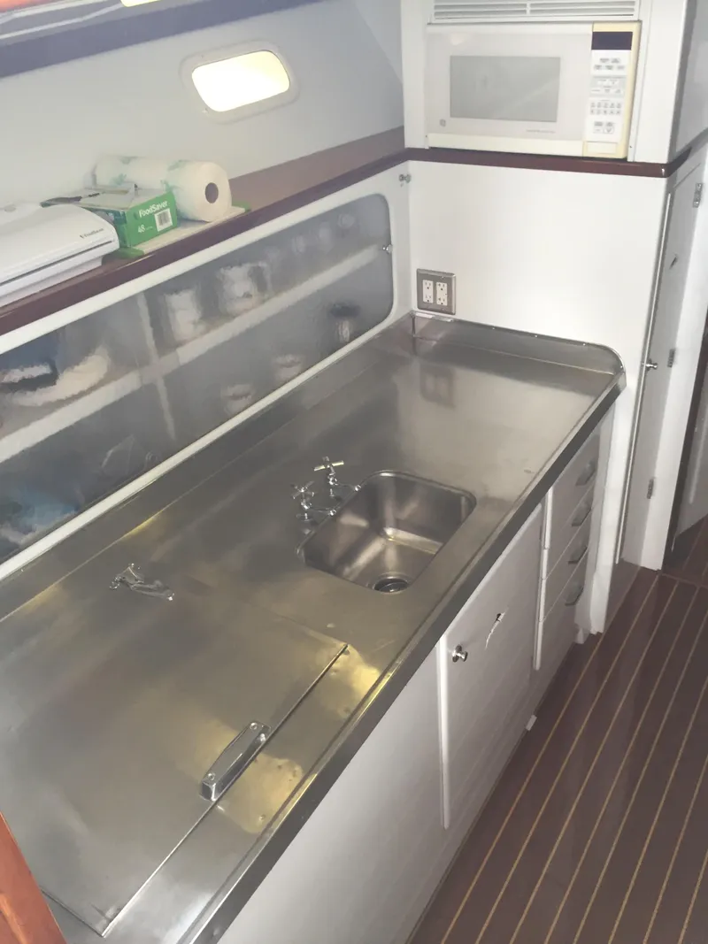 Slide: The Image of 1965 Rybovich 37 Sportfish galley with stainless steel countertop and microwave. - 1