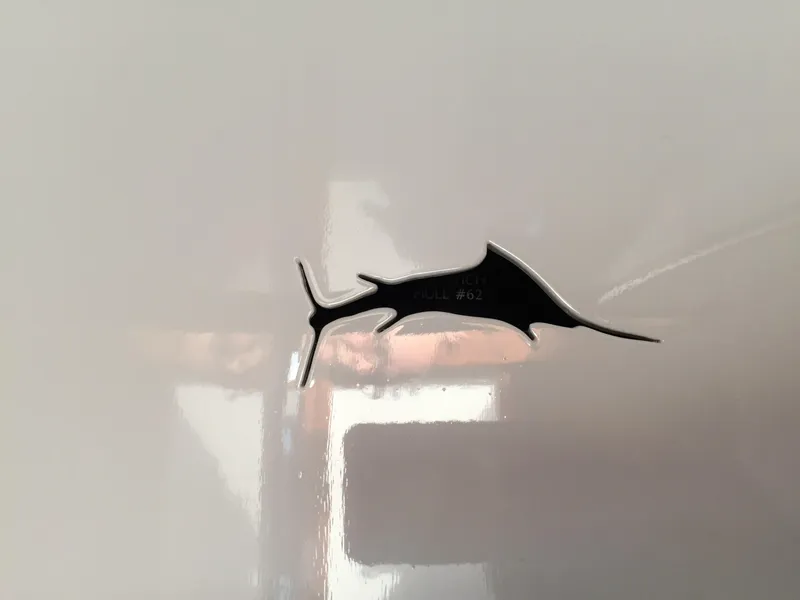 Slide: The Image of 1965 Rybovich 37 Sportfish marlin emblem on glossy white surface. - 14