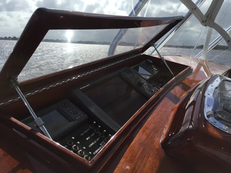 Slide: The Image of 1965 Rybovich 37 Sportfish dashboard with open panel, overlooking water. - 18