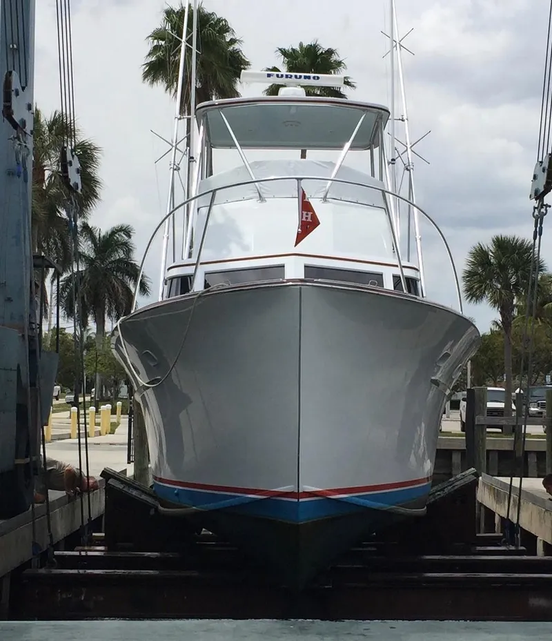 Slide: The Image of 1965 Rybovich 37 Sportfish boat in dry dock, surrounded by palm trees. - 21