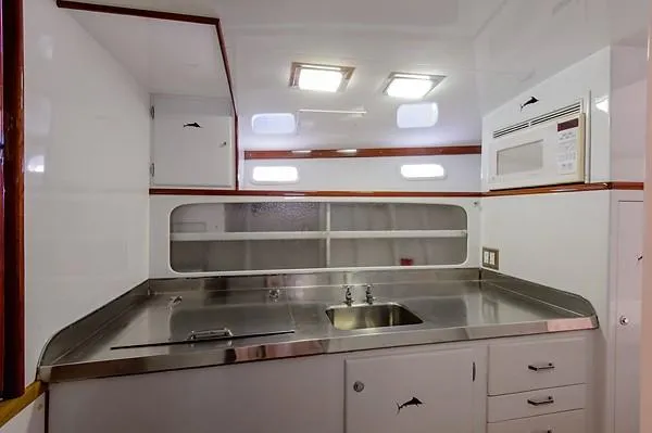 Slide: The Image of 1965 Rybovich 37 Sportfish yacht kitchen with stainless steel counters and modern appliances. - 27
