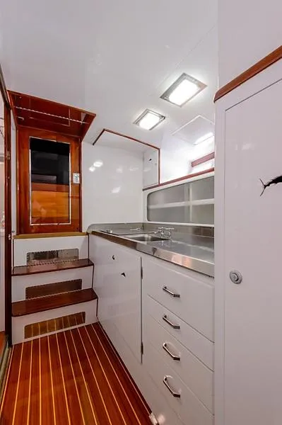 Slide: The Image of Interior of 1965 Rybovich 37 Sportfish with sleek cabinetry and wooden flooring. - 28