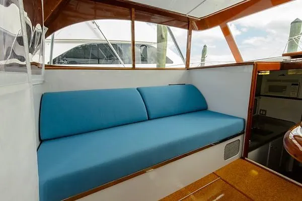 Slide: The Image of 1965 Rybovich 37 Sportfish interior with blue cushioned seating and wooden accents. - 29