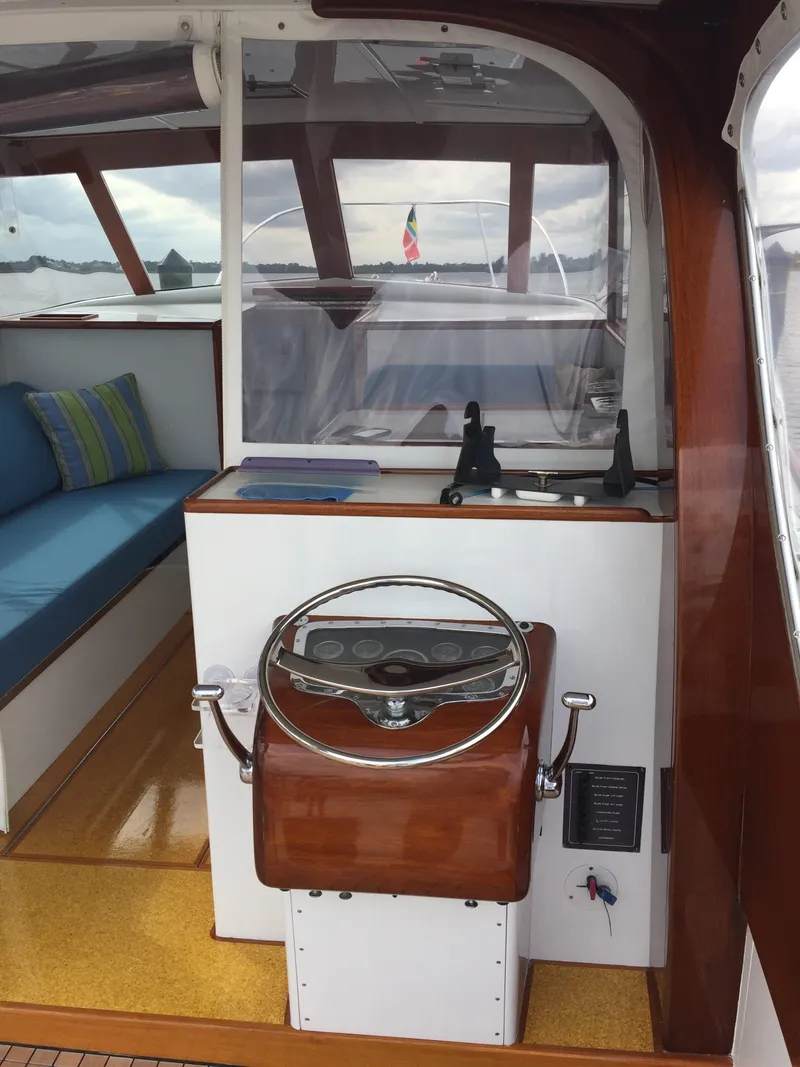 Slide: The Image of 1965 Rybovich 37 Sportfish interior with wooden helm and blue seating. - 4