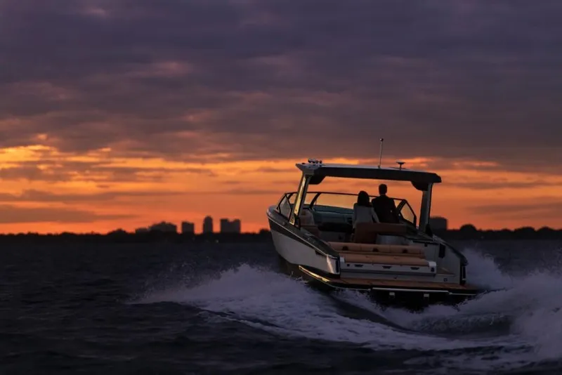 Slide: The Image of 2023 Aviara AV32 boat cruising at sunset on open water. - 2