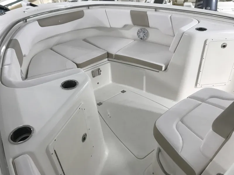 Slide: The Image of 2024 Robalo R302 boat interior with white cushioned seating and storage compartments. - 14
