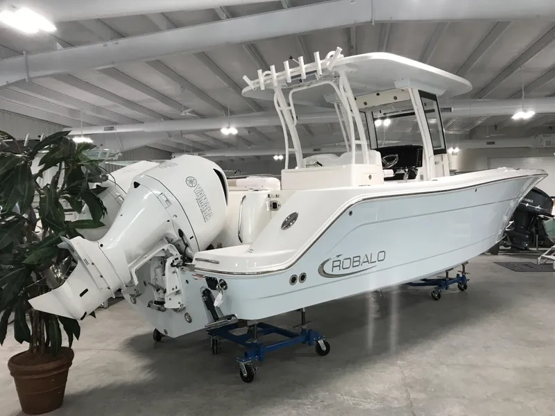 Slide: The Image of 2024 Robalo R302 boat in showroom, side view with twin outboard engines. - 2