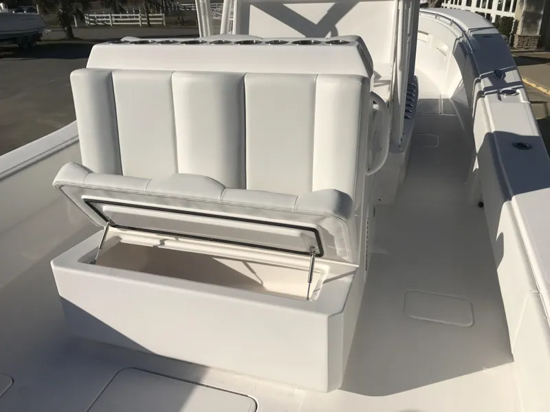Slide: The Image of 2024 Invincible 36 boat with white cushioned seating and storage compartment. - 16