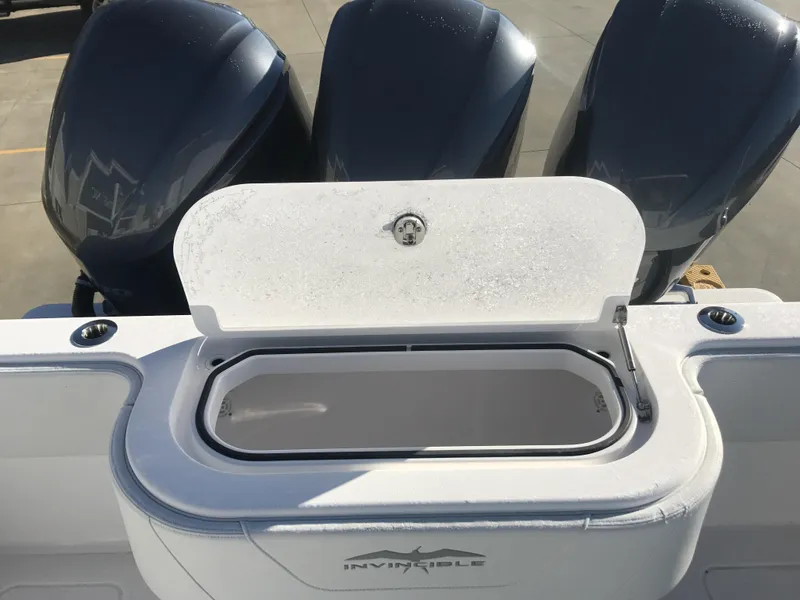 Slide: The Image of 2024 Invincible 36 boat with open storage compartment and triple outboard engines. - 18