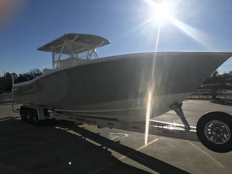 Slide: The Image of 2024 Invincible 36 boat on trailer under bright sunlight. - 2