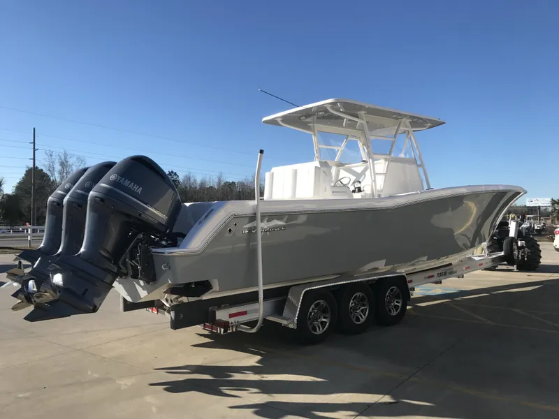 Slide: The Image of 2024 Invincible 36 boat with triple Yamaha engines on a trailer. - 3
