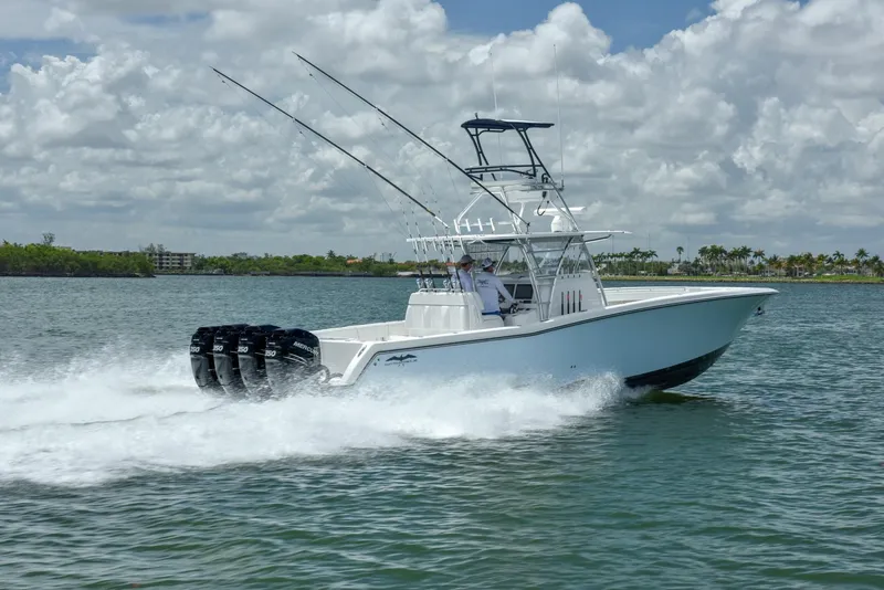 Slide: The Image of 2024 Invincible 42 boat speeding on water with four outboard motors. - 2