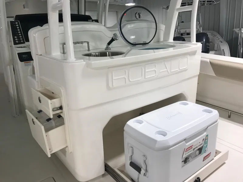 Slide: The Image of 2024 Robalo R302 boat interior with sink, storage drawers, and cooler. - 10