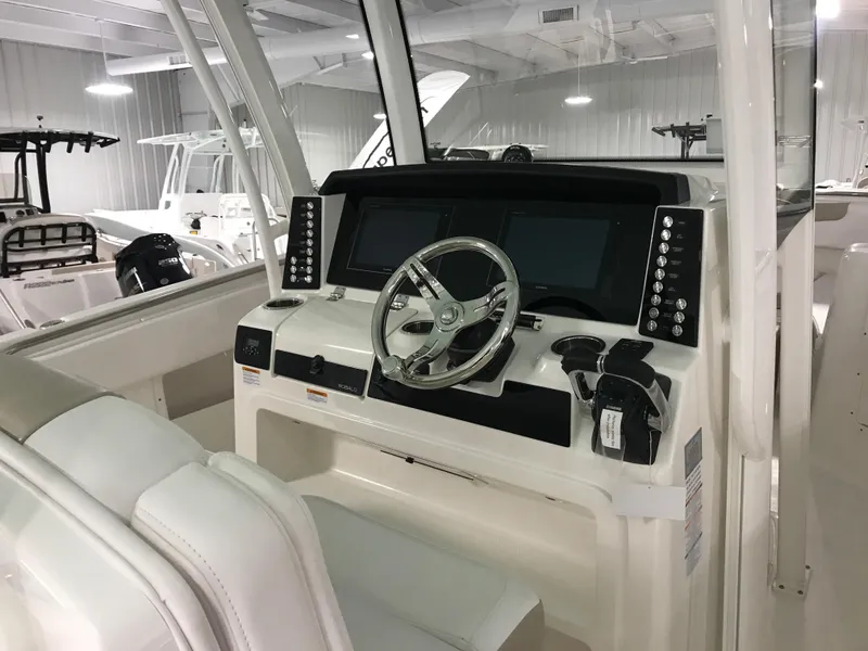 Slide: The Image of 2024 Robalo R302 boat helm with dual screens and modern controls. - 13