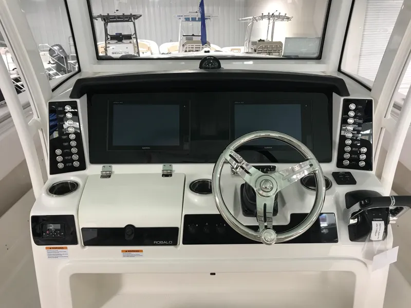 Slide: The Image of 2024 Robalo R302 boat dashboard with dual screens and steering wheel. - 14