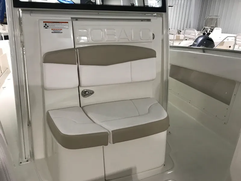 Slide: The Image of 2024 Robalo R302 boat interior seating in white and beige. - 15