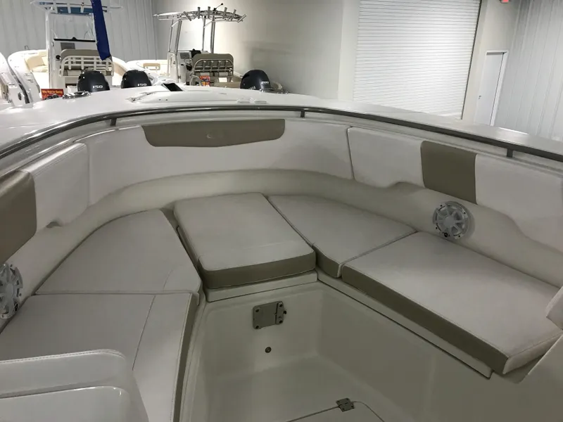 Slide: The Image of 2024 Robalo R302 boat interior with cushioned seating in a showroom. - 20
