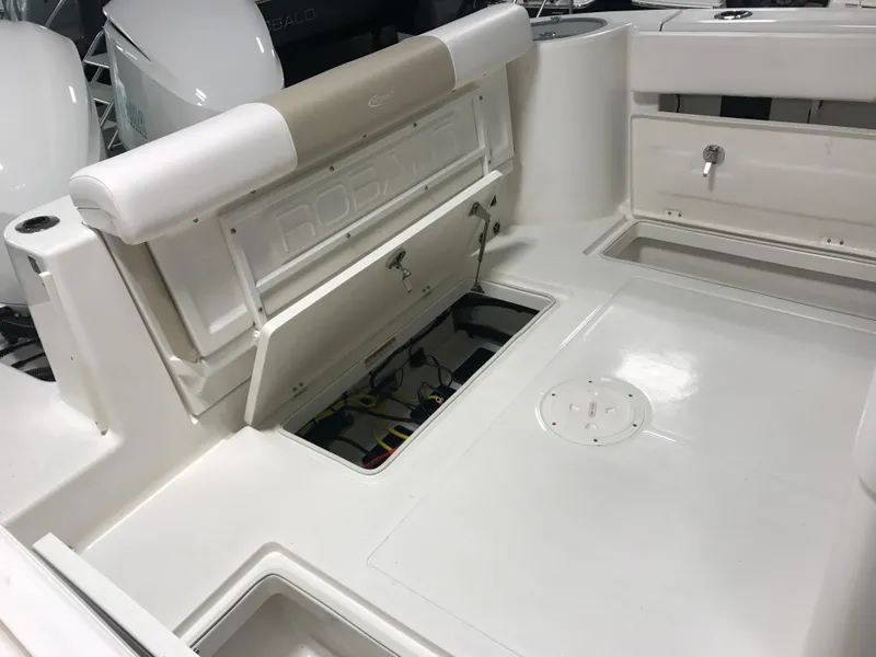 Slide: The Image of 2024 Robalo R302 boat interior with open storage compartments and white seating. - 6