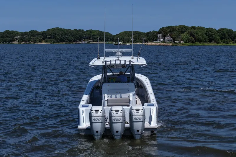 Slide: The Image of 2021 SeaVee 370z boat with triple 400 engines on a calm lake. - 11