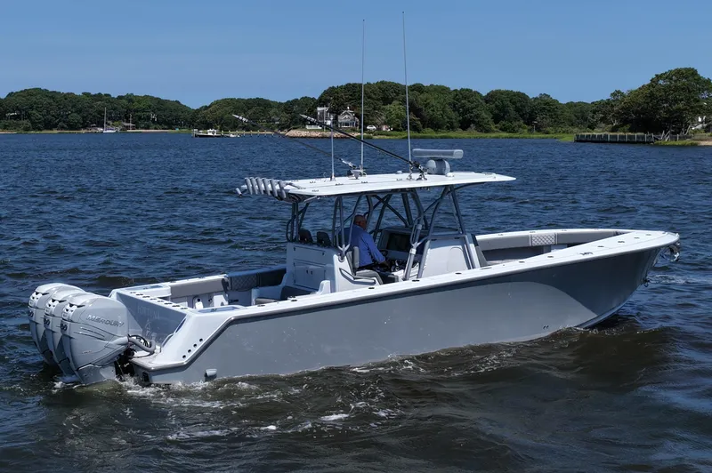 Slide: The Image of 2021 SeaVee 370z boat cruising on a calm lake with scenic background. - 13