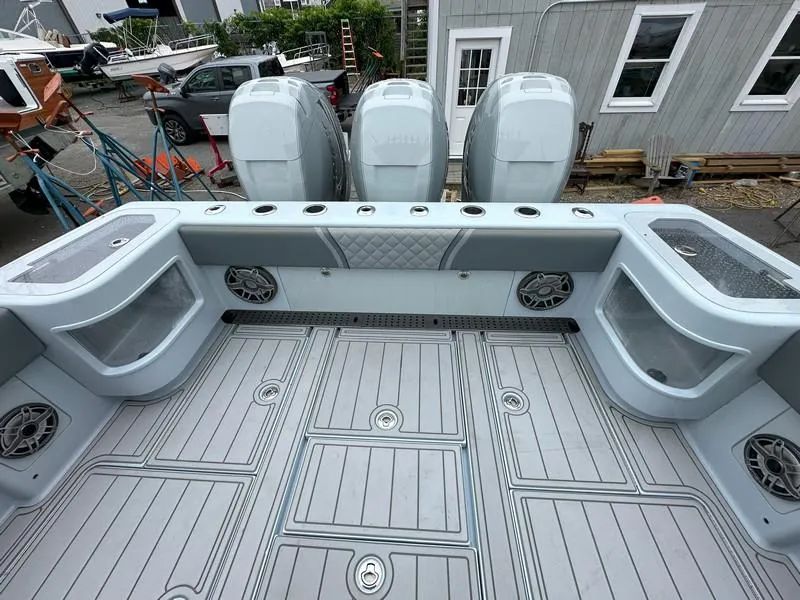 Slide: The Image of 2021 SeaVee 370z boat deck with triple outboard engines and spacious storage compartments. - 22