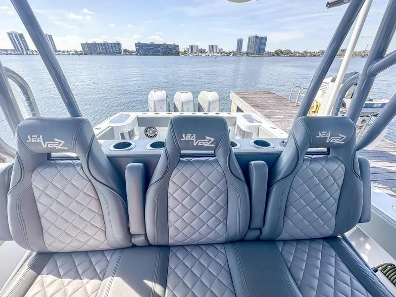 Slide: The Image of 2021 SeaVee 370z boat interior with three quilted seats, overlooking a waterfront cityscape. - 33