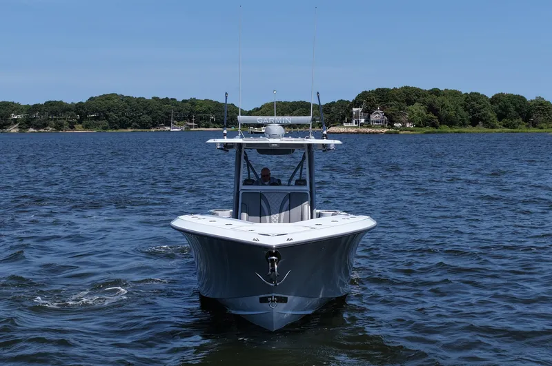 Slide: The Image of 2021 SeaVee 370z boat cruising on a calm lake with a scenic shoreline. - 4