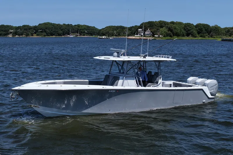 Slide: The Image of 2021 SeaVee 370z boat cruising on a lake with lush green shoreline. - 7