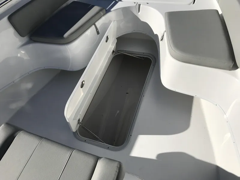 Slide: The Image of 2024 Cape Horn 27 XS boat interior with open storage compartment and cushioned seating. - 11