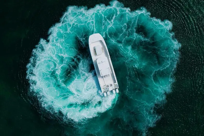 Slide: The Image of Aerial view of 2024 Invincible 40 Catamaran creating a circular wake in the ocean. - 2