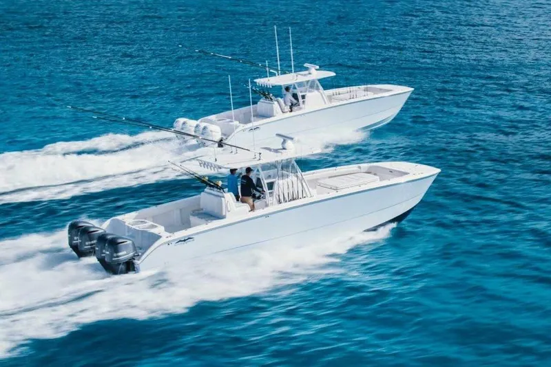 Slide: The Image of Two 2024 Invincible 40 Catamaran boats cruising on clear blue water. - 3