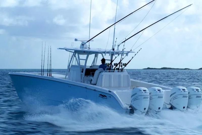 Slide: The Image of 2024 Invincible 40 Catamaran cruising on the ocean with fishing rods and four outboard motors. - 5