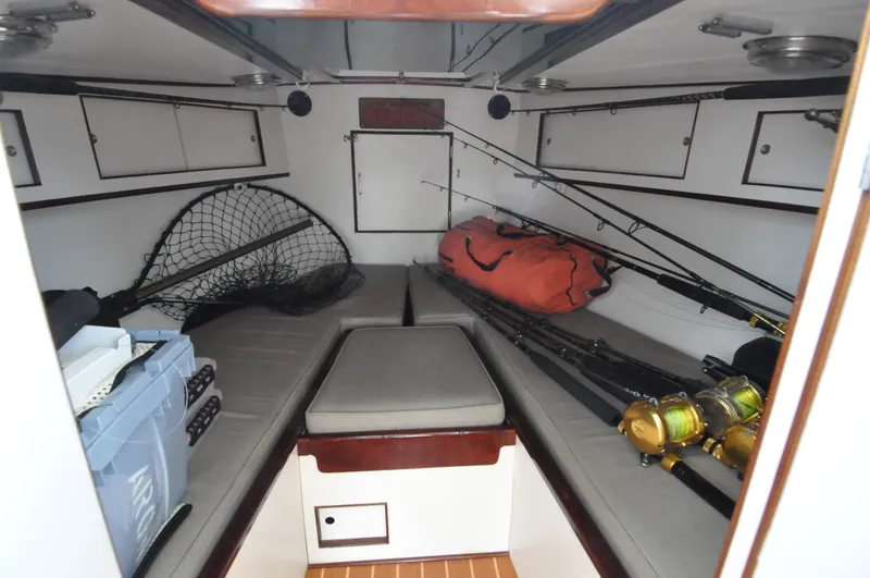 Slide: The Image of 1974 Bertram 31 Sportfisher cabin interior with fishing gear and storage. - 13
