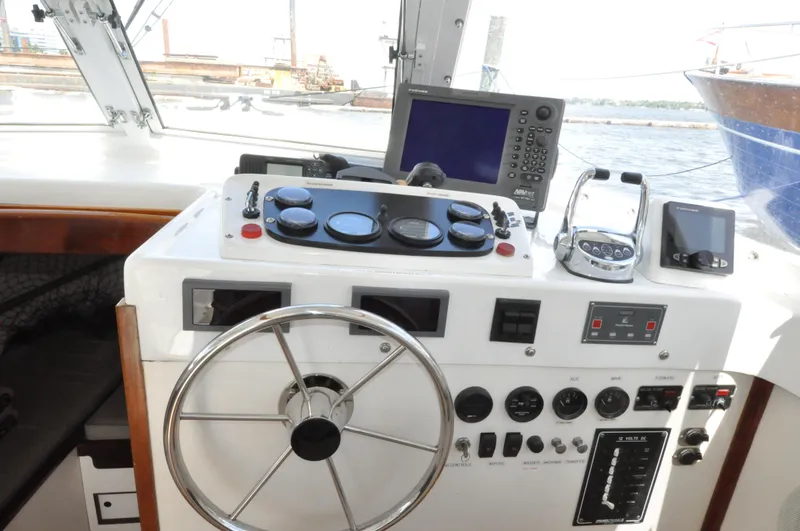 Slide: The Image of 1974 Bertram 31 Sportfisher helm with steering wheel, gauges, and navigation equipment. - 3