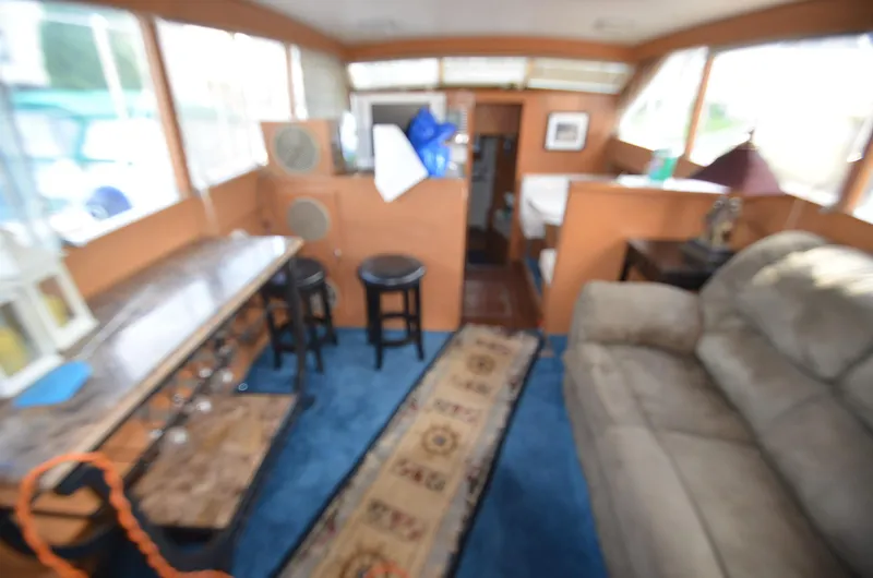 Slide: The Image of 1964 Chris-Craft Constellation boat interior with blue carpet, beige sofa, and wooden furnishings. - 11